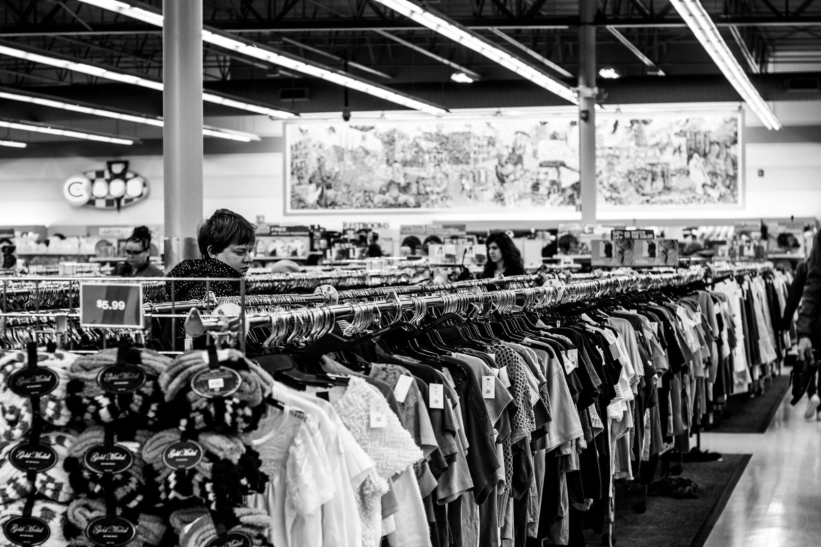 grayscale photography of people inside a clothing shop